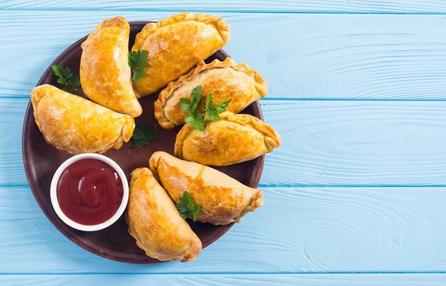 Foto latijns-amerikaanse gebakken rundvlees-empanadas met sauzen voedselachtergrond