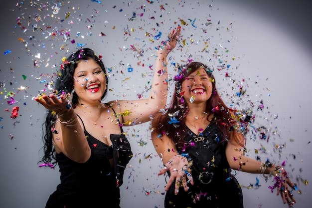 Latijns-Amerikaanse meisjes poseren en vieren het nieuwe jaar met ballonnen en confetti