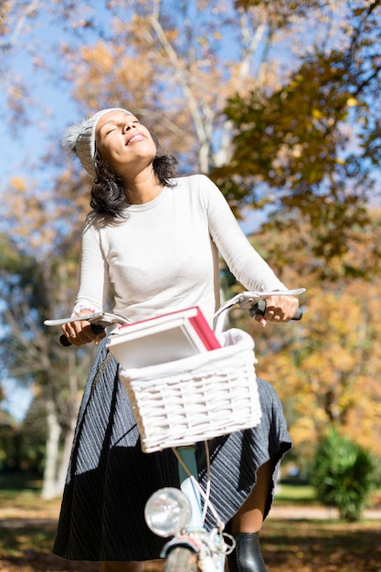 Latijns-Amerikaanse vrouw haar fiets rijden in het park.