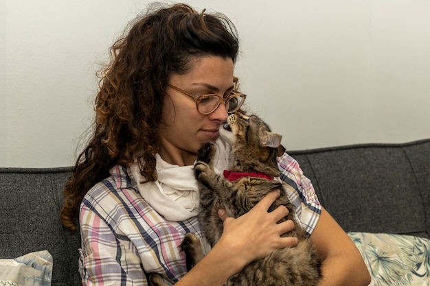 Latijns-Amerikaanse vrouw knuffelt en speelt liefdevol met haar kat