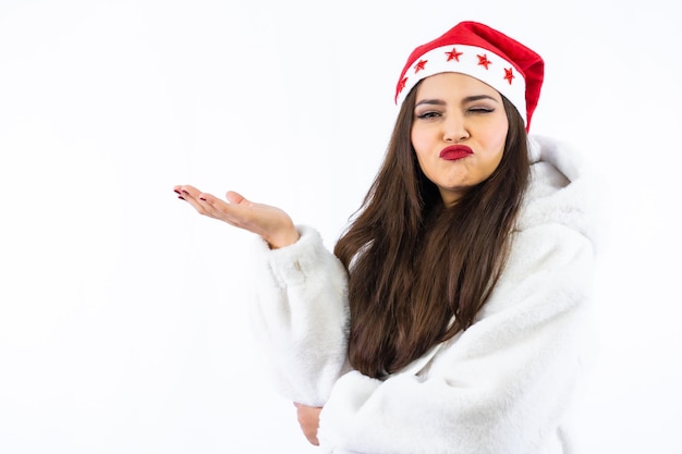 Latijns brunette meisje met Kerstmis met een witte achtergrond, met een kerstmuts met sterren, portret camera kijken en knipogen, kopieer ruimte