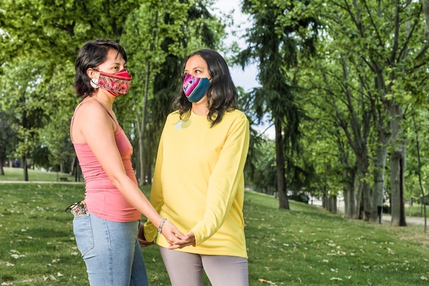 Latijns jong lesbisch koppel geniet van geluk in Zuid-Amerika BoliviaansLevensstijlvrouw met een handgemaakt stoffen gezichtsmasker voor Coronavirus LGTBQ