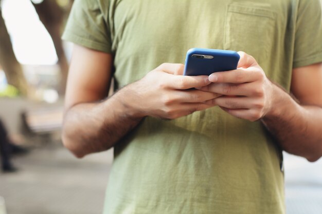 Latijns-man typen op zijn telefoon.