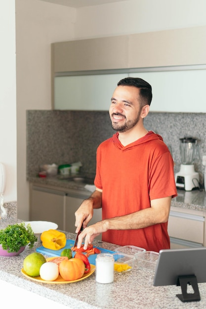 Latijnse man kookt een gezonde lunch in de keuken