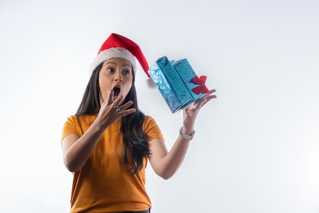 Foto latijnse vrolijke vrouw met vliegende geschenkendoos. witte achtergrond