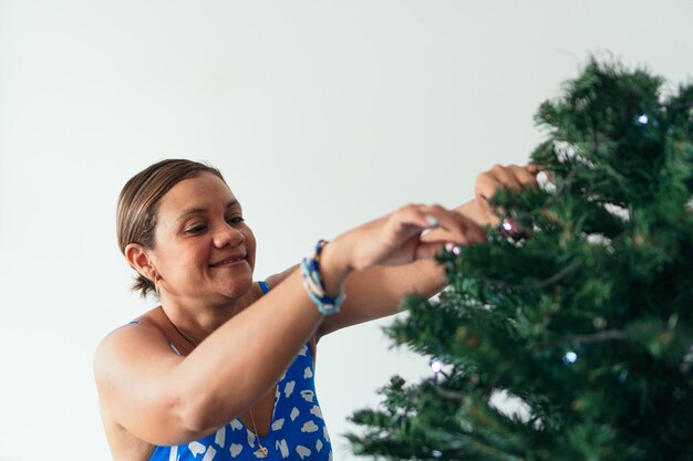 Latijnse vrouw die een kerstboom versiert