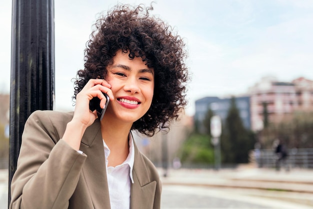 Latijnse vrouw die lacht gelukkig praten via de mobiele telefoon