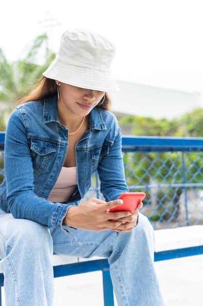 Latijnse vrouw die mobiele telefoon met behulp van bij park