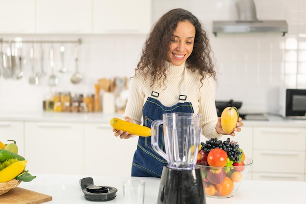 Latijnse vrouw die sap maakt in de keuken - voor vegetariërs