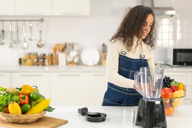 Latijnse vrouw die sap maakt in de keuken - voor vegetariërs