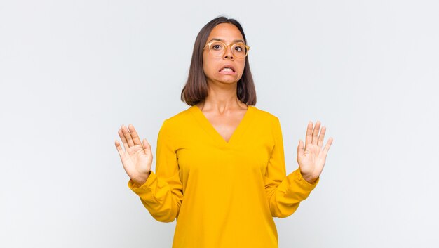 Foto latijnse vrouw die zich stomverbaasd en bang voelt, bang is voor iets beangstigend, met open handen naar voren en zegt: blijf weg