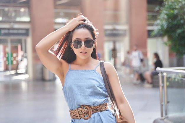 Latijnse vrouw met een zonnebril die modekleren draagt portret van een vrouw met stralende zonnestralen