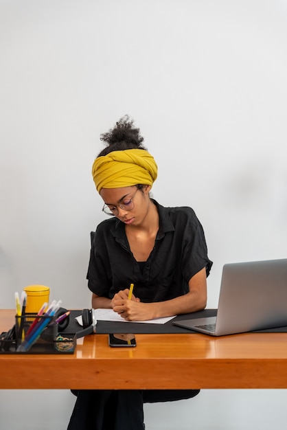 Foto latijnse vrouw thuis werken met laptop en documenten