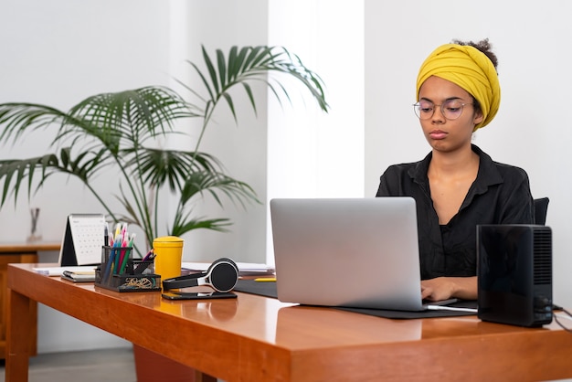 Latijnse vrouw thuis werken met laptop en documenten