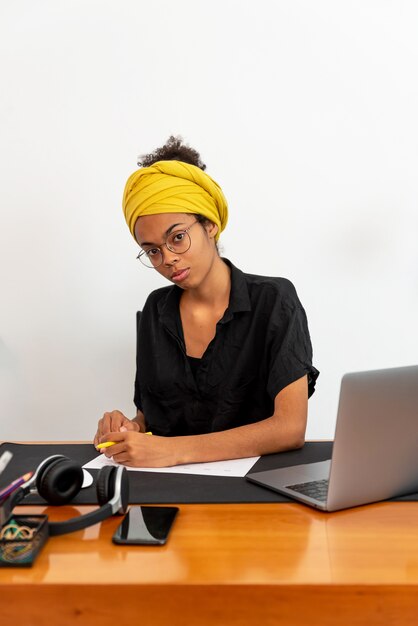 Latijnse vrouw thuis werken met laptop en documenten