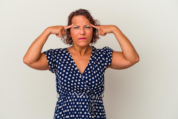 Latijnse vrouw van middelbare leeftijd geïsoleerd op een witte achtergrond gericht op een taak, wijsvingers wijzend hoofd houden.