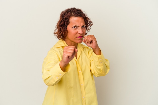 Latijnse vrouw van middelbare leeftijd geïsoleerd op een witte achtergrond gooien van een punch, woede, vechten als gevolg van een argument, boksen.