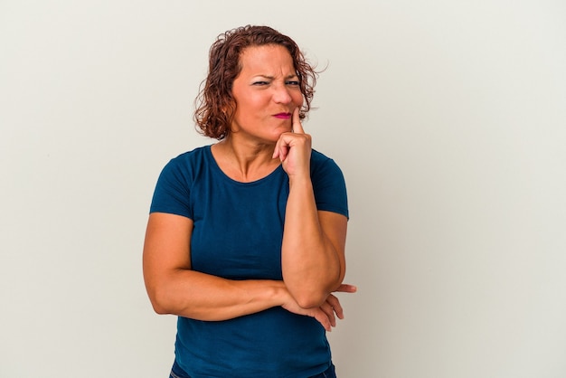 Latijnse vrouw van middelbare leeftijd geïsoleerd op een witte achtergrond overweegt, het plannen van een strategie, na te denken over de manier van een bedrijf.