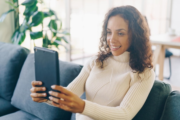 Latijnse vrouw videoconferentie op tablet met blij gevoel