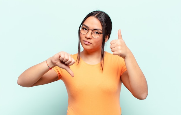 Latijnse vrouw voelt zich verward, geen idee en onzeker, en weegt het goede en het slechte af in verschillende opties of keuzes