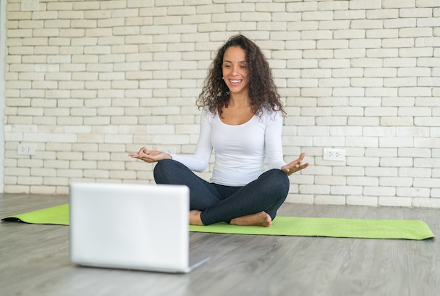 Latijnse vrouwelijke influencer die yoga online geeft