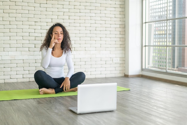 Latijnse vrouwelijke influencer die yoga online geeft