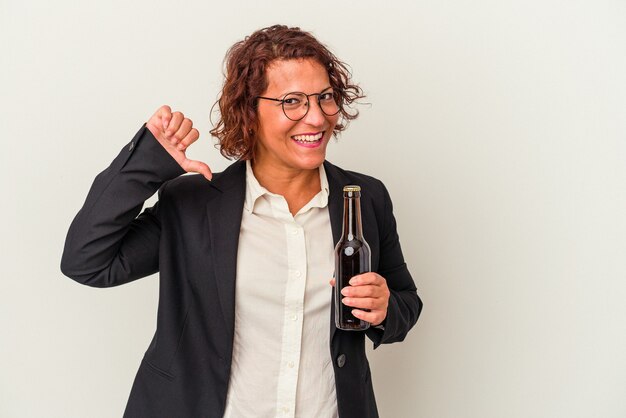 Latijnse zakenvrouw van middelbare leeftijd met een biertje geïsoleerd op een witte achtergrond voelt zich trots en zelfverzekerd, voorbeeld om te volgen.