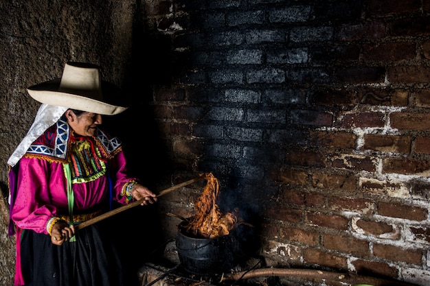 Foto donna andina latinoamericana che tinge la lana di pecora con prodotti naturali ancestrali peruviani