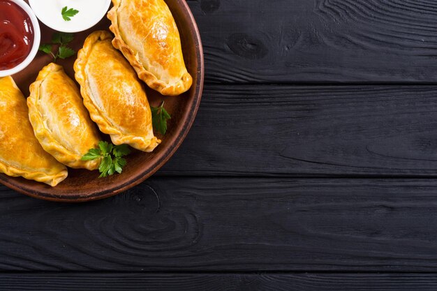 Photo latin american baked beef empanadas with sauces food background