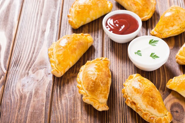 Latin American baked beef empanadas with sauces Food background