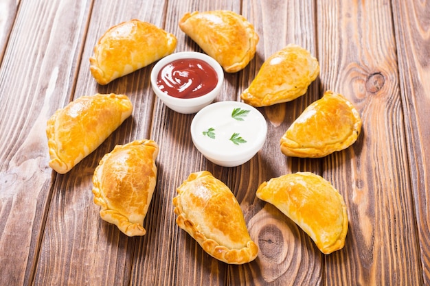 Photo latin american baked beef empanadas with sauces food background