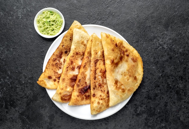 Latin American fried empanadas with avocado on a stone table