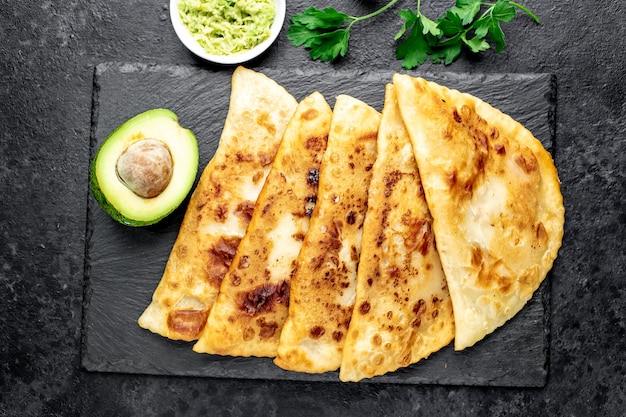 Latin American fried empanadas with avocado on a stone table