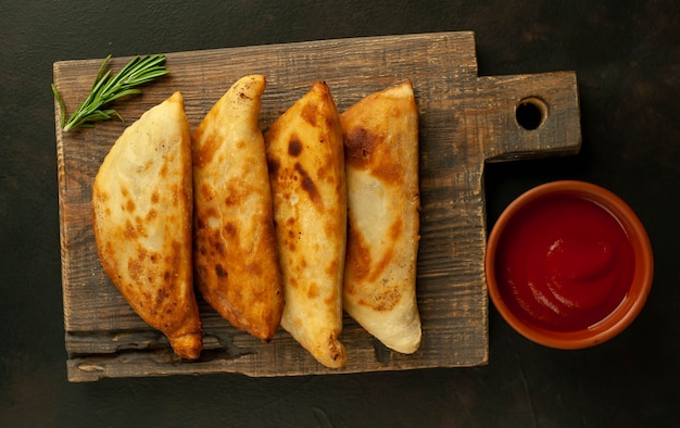 Latin American fried empanadas with tomato sauce.