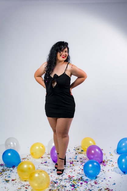 Latin American girls posing and celebrating the new year with balloons and confetti