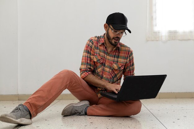 Latin American man with his laptop computer is a programmer and specializes in web development