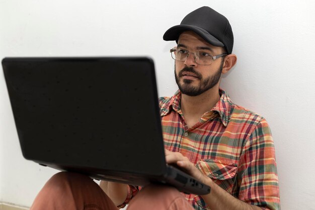 Latin American man with his laptop computer is a programmer and specializes in web development