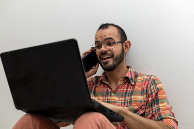 Latin American man with his laptop computer is a programmer and specializes in web development