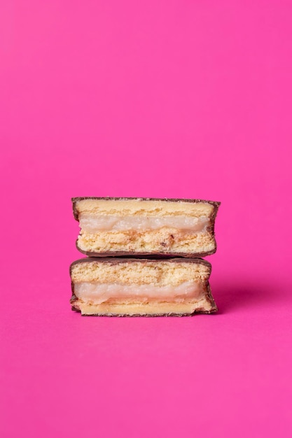 Foto dessert dolce latinoamericano chiamato alfajor di amido di mais di diversi sapori e sfondo colorato