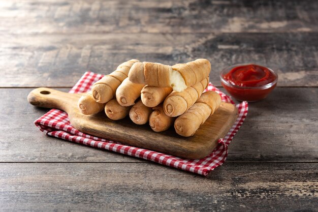 Latin American tequeos stuffed with cheese on wooden table