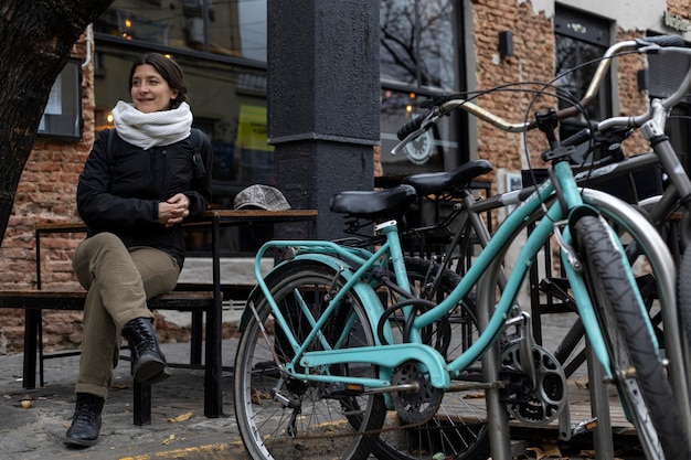 ブエノスアイレスの路上で自転車の隣に座っているラテンアメリカの女性