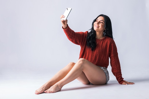 Латиноамериканка использует свой телефон и создает контент для своих социальных сетей