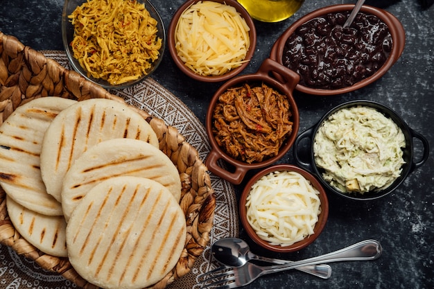 Latin arepas with various ingredients around