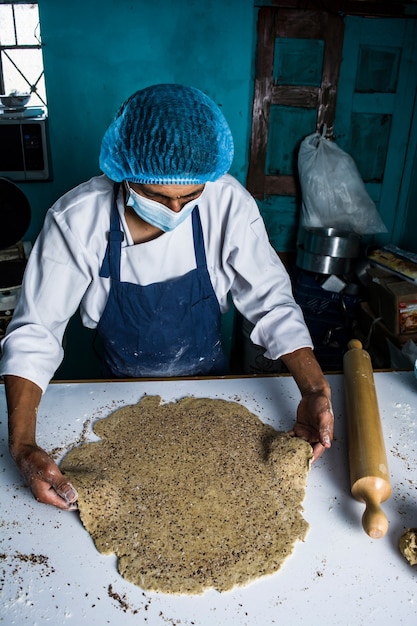 Latin baker preparing the dough and baking colored brioche breads and cookies