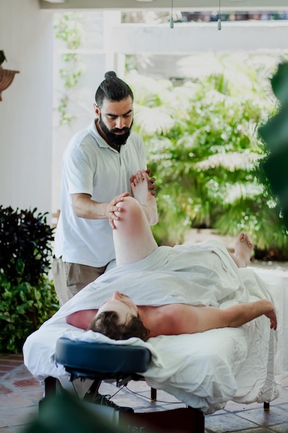 Latin bearded man giving a massage in a spa