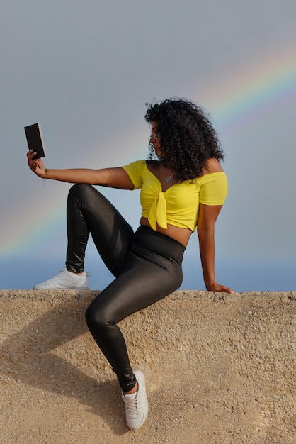 Latin black woman sitting with a notepad outdoors,