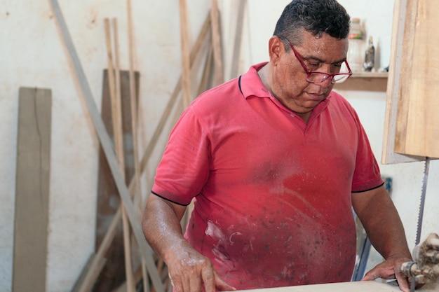 Latin Carpenter aan het werk in zijn atelier