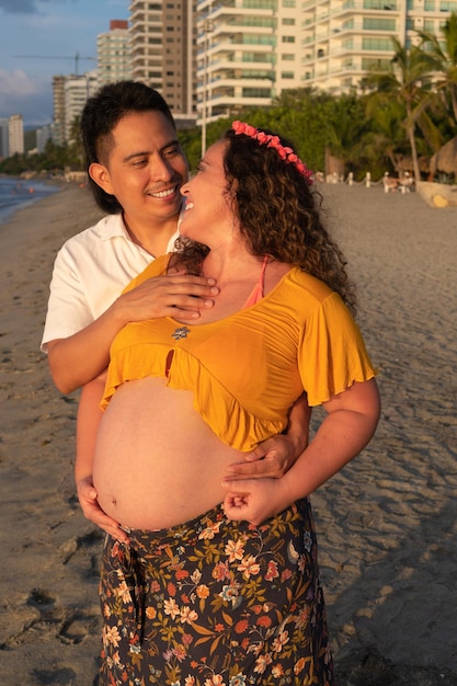Latin couple pregnant woman in the beach