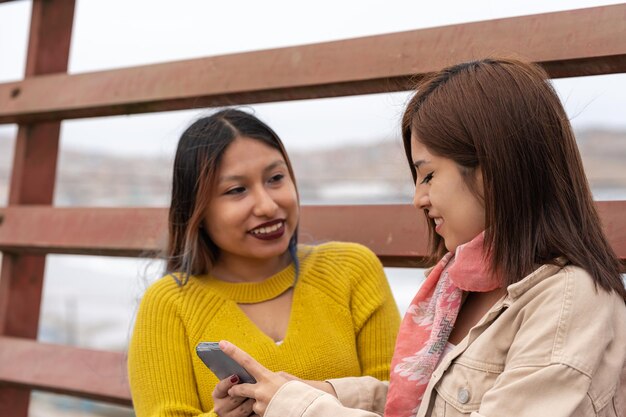 Latin friends using the mobile outdoors