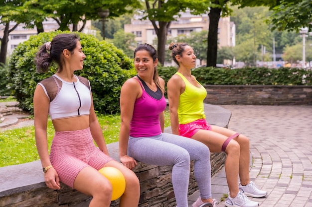 Photo latin girl doing sports in a park in the city, lifestyle a healthy life, teacher giving instructions to the students doing leg exercises